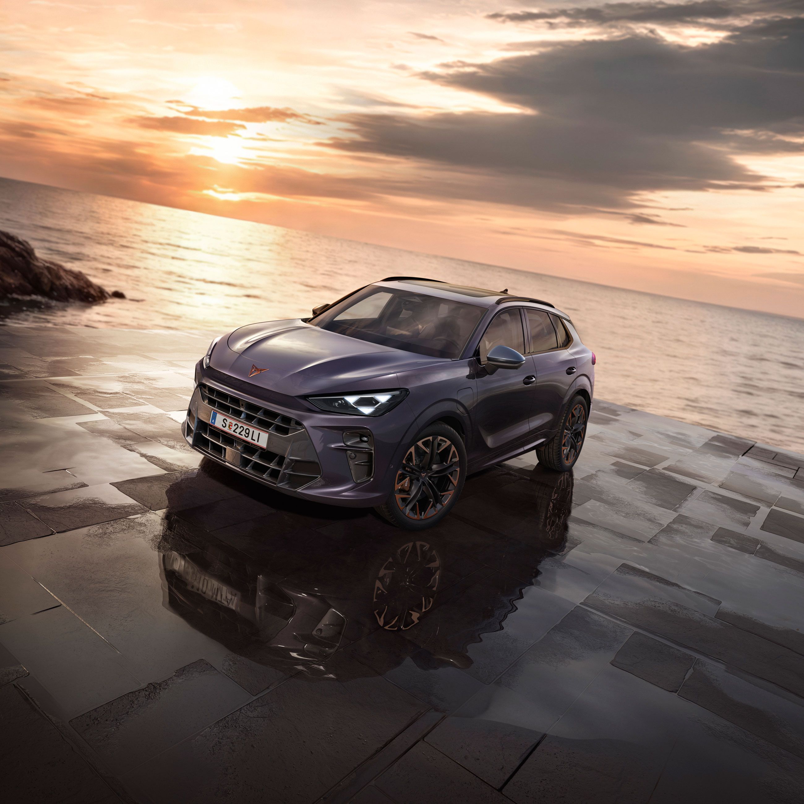 Ein CUPRA Terramar parkt zwischen Felsen an der Meeresküste.