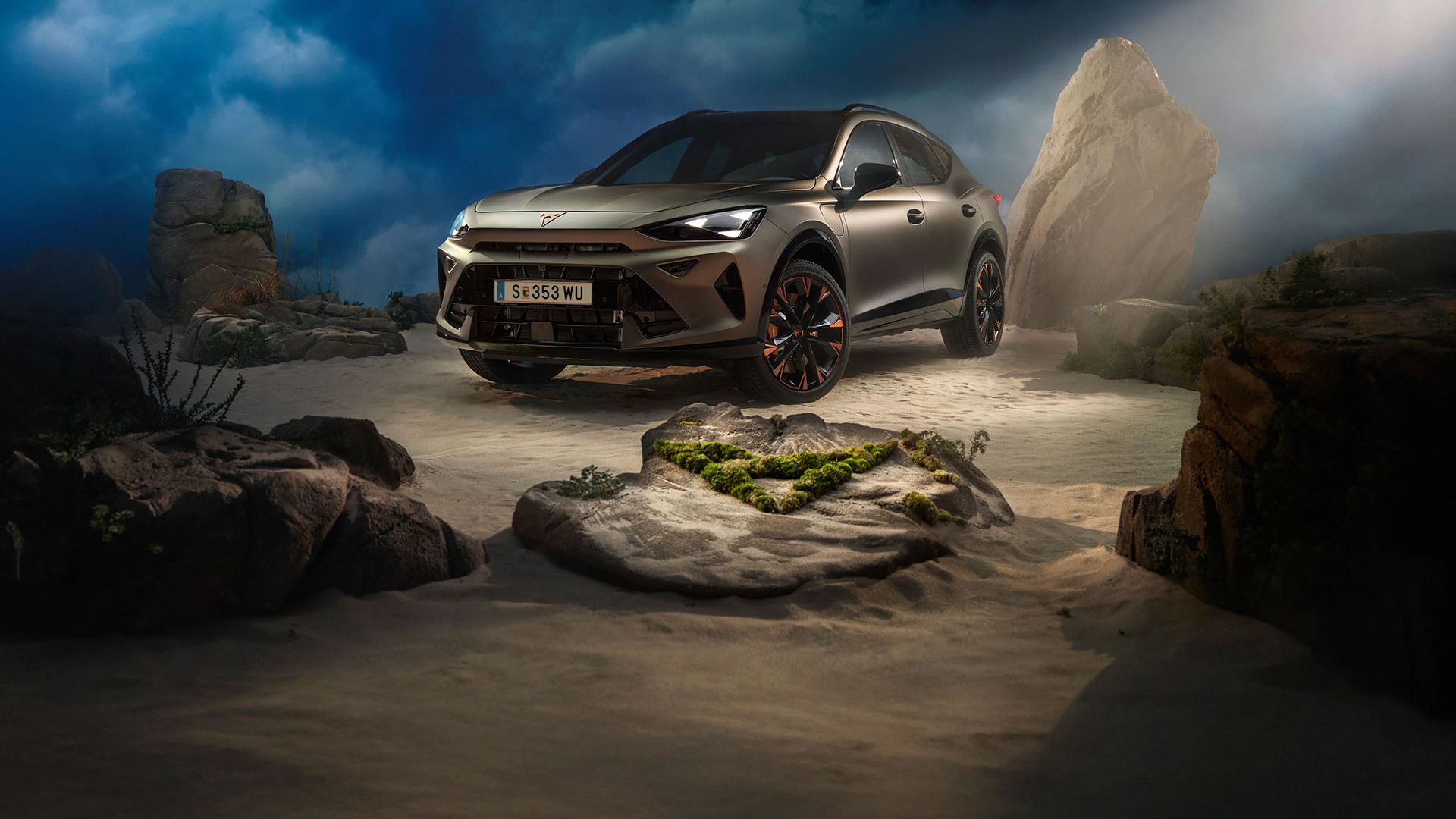 Ein CUPRA Formentor VZ in Bronze steht dramatisch beleuchtet in einer felsigen, nebeligen Landschaft. Eine Lichtstrahl beleuchtet das Fahrzeug und betont seine Konturen. Im Hintergrund sind Felsen und Pflanzen zu sehen.