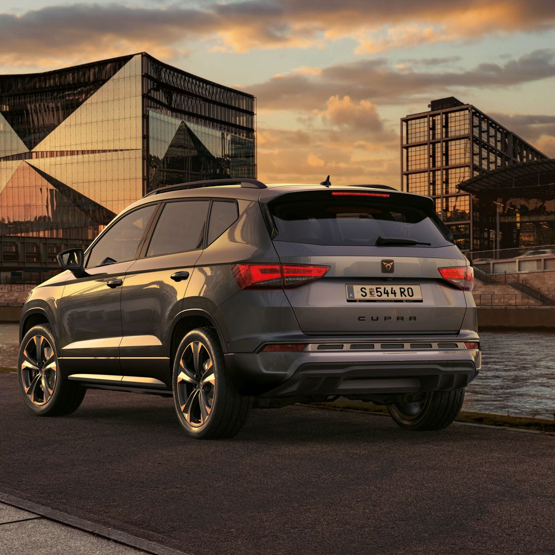 Rückansicht des CUPRA Ateca SUV bei Sonnenuntergang, mit Fokus auf den neuen tiefer gelegten Frontgrill mit Luftklappen und den neuen Heckdiffusor, beide optimiert für das Design und die Aerodynamik.