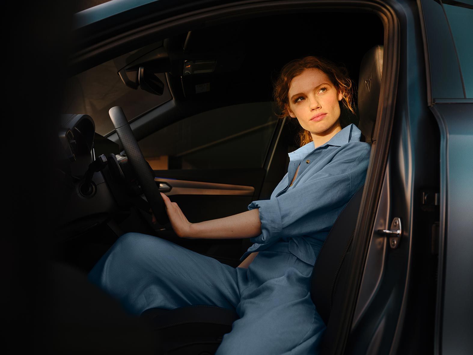 Жінка сидить на місці водія в CUPRA Formentor.