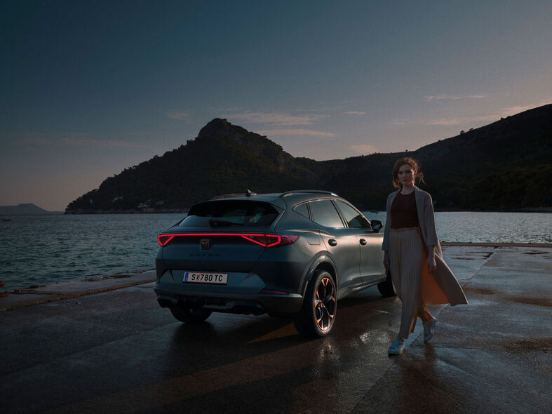CUPRA Formentor: вигляд ззаду Жінка стоїть біля автомобіля.